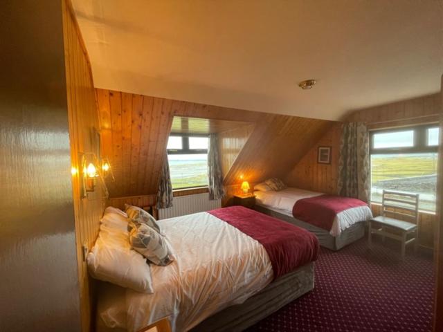 a hotel room with two beds and a window at Ard Einne House Bed & Breakfast in Inis Mor