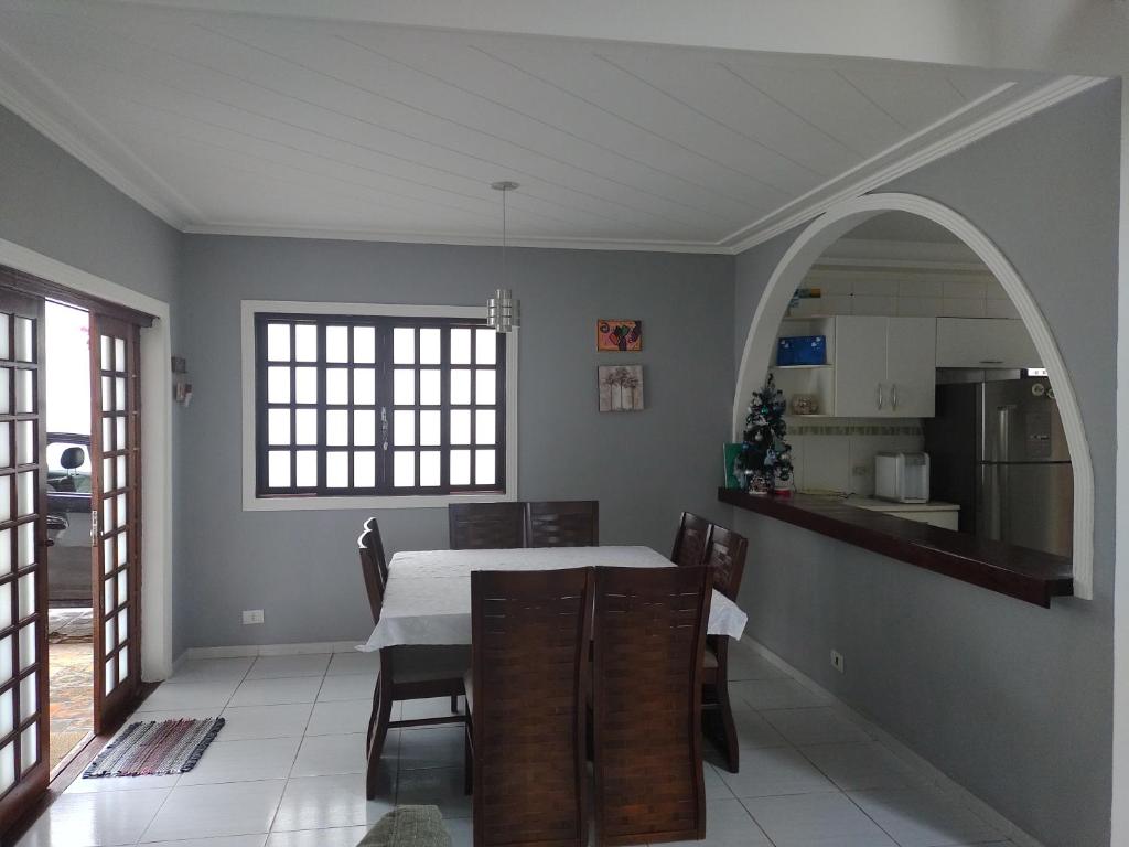 a kitchen and dining room with a table and chairs at Linda Casa, 3 quartos, acomoda 10 pessoas, há 1,5 km da praia da Enseada in Guarujá