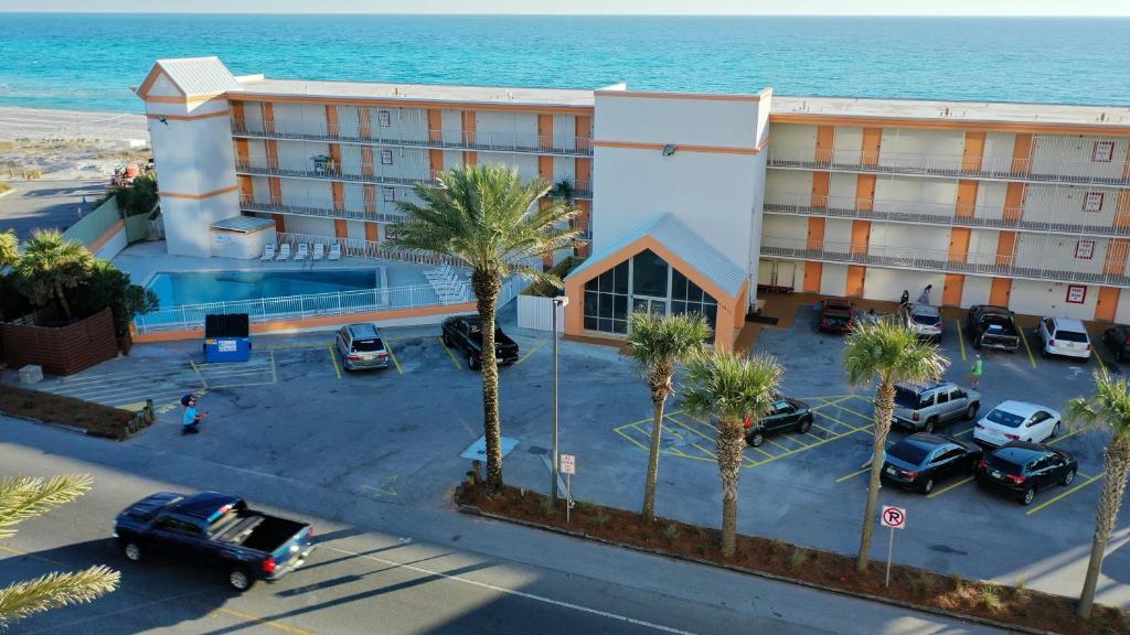 an aerial view of a hotel with palm trees and the ocean at The Reef At Seahaven Beach Resorts in Panama City Beach