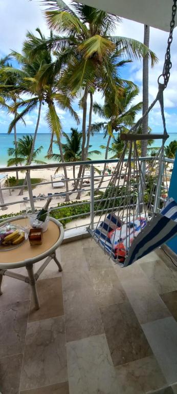 uma varanda com cadeiras e uma mesa e vista para a praia em Suite just over the beach-Adults only em Punta Cana