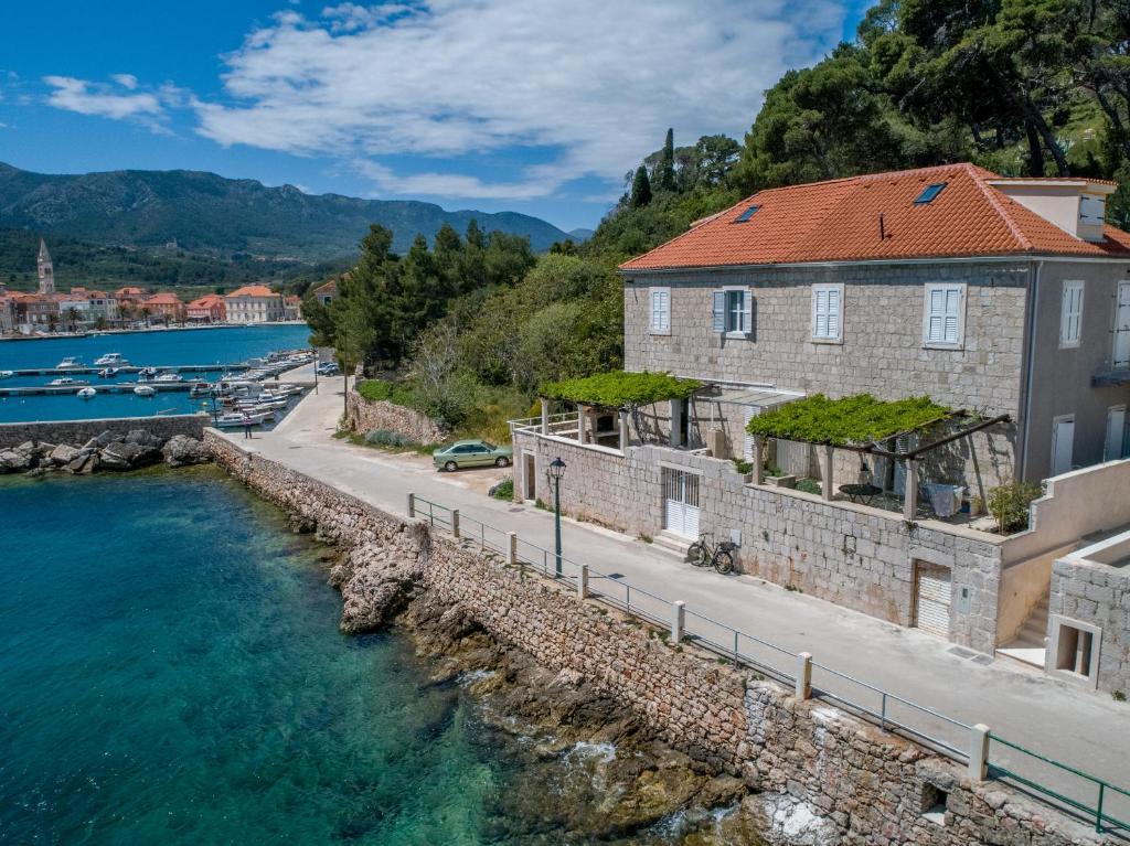 a house on the shore of a body of water at Seafront apartment Marina in Jelsa