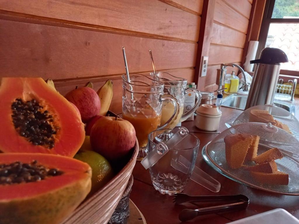 a table with a basket of fruit on a counter at Pousada Recanto Viva a Vida in Domingos Martins