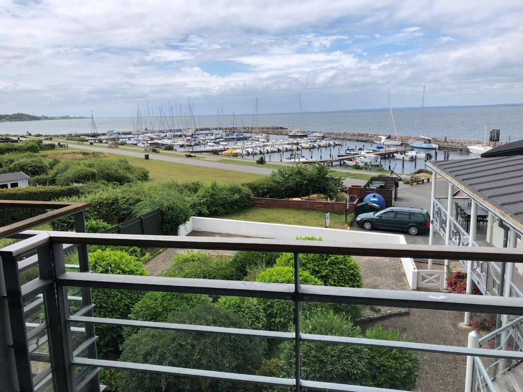 a balcony with a view of a marina at Havudsigt, skøn lille lejlighed in Tranekær