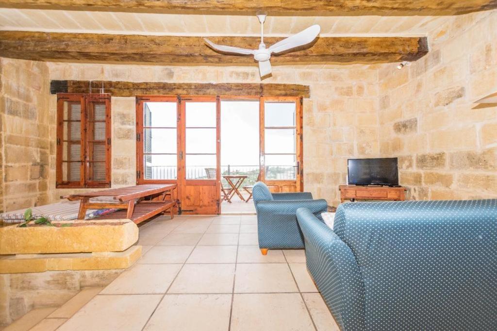 a living room with two blue chairs and a table at Farmhouse Cala2 in Qala