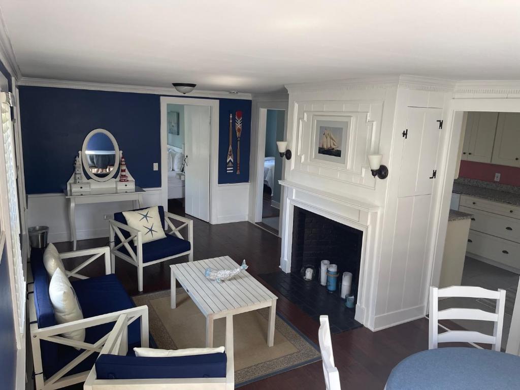 a living room with a fireplace and a table and chairs at The Escape Inn in South Yarmouth