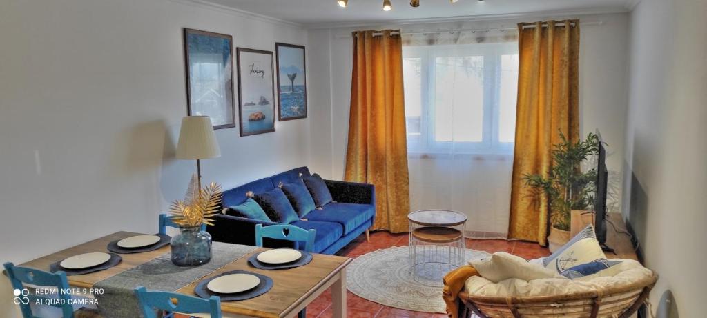 ein Wohnzimmer mit einem blauen Sofa und einem Tisch in der Unterkunft Malpica Greek Home in Malpica