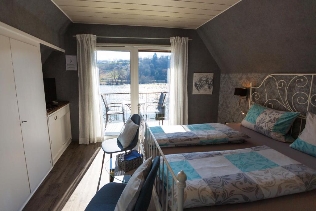 a bedroom with two beds and a balcony at Der Weinladen in Kröv