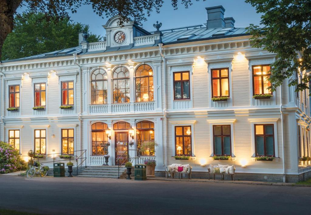 un grande edificio bianco con una torre dell'orologio in cima di Karstorp Säteri – Hotell och Konferens a Skövde