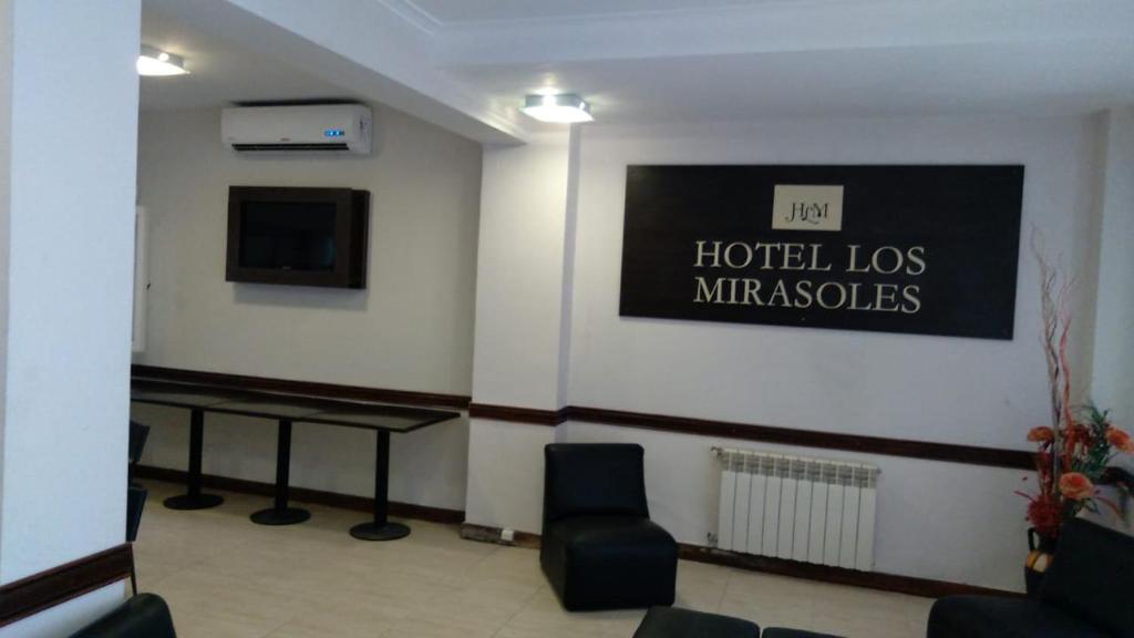 una sala d'attesa con un cartello Hotel Los Miracles sul muro di Los mirasoles a Necochea