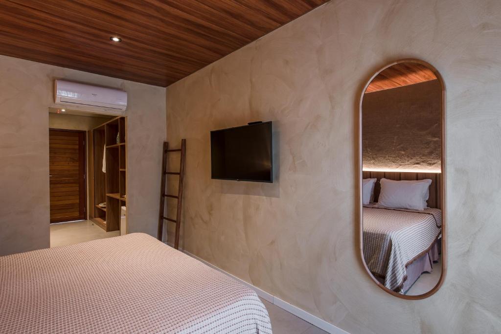 a bedroom with two beds and a mirror at Vila Sal Boutique Noronha in Fernando de Noronha