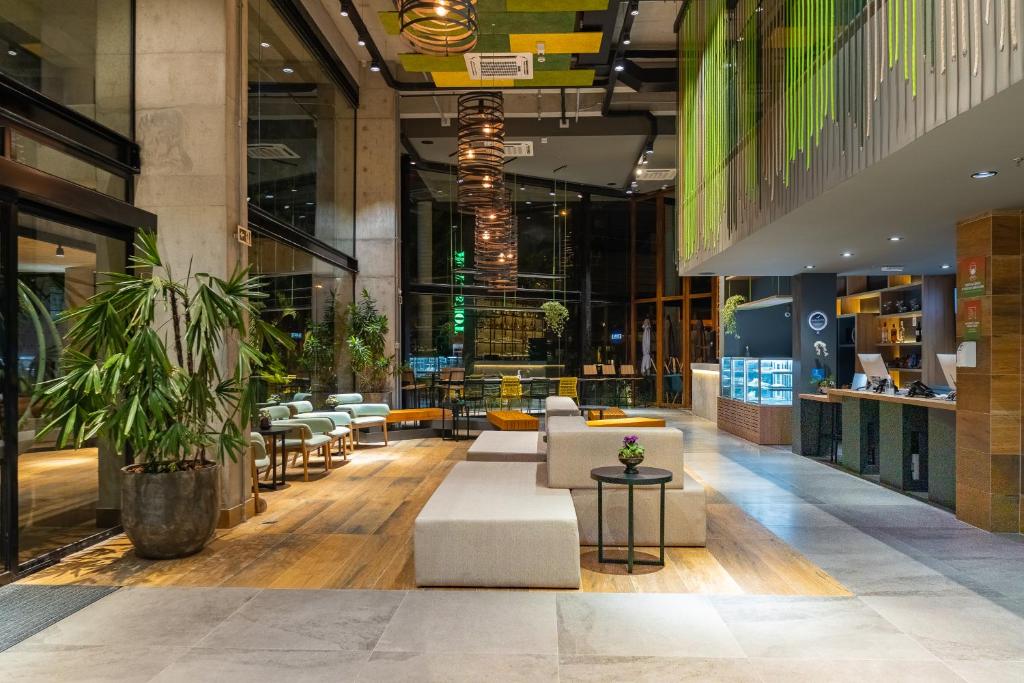 a lobby of a building with couches and tables at ibis Styles Porto Alegre Moinhos de Vento in Porto Alegre