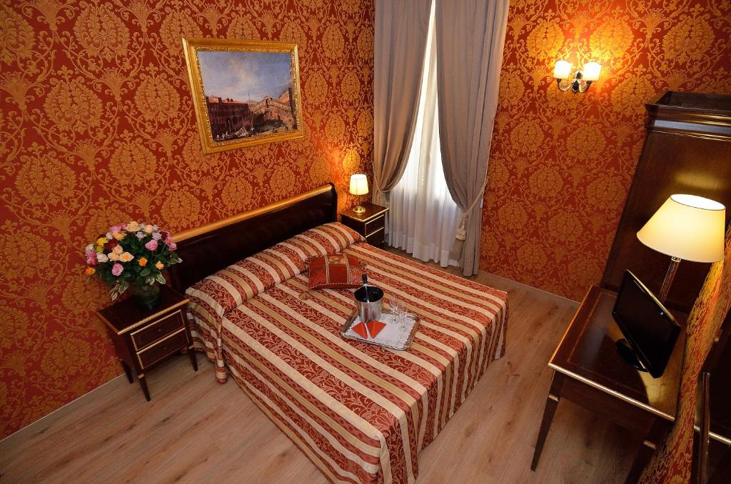 a hotel room with a bed and a table at Residenza Goldoni in Venice