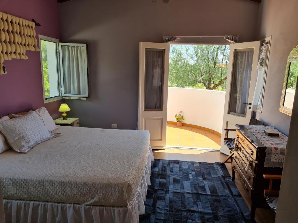 une chambre avec un lit et une grande fenêtre dans l'établissement Los Laureles, à Cafayate