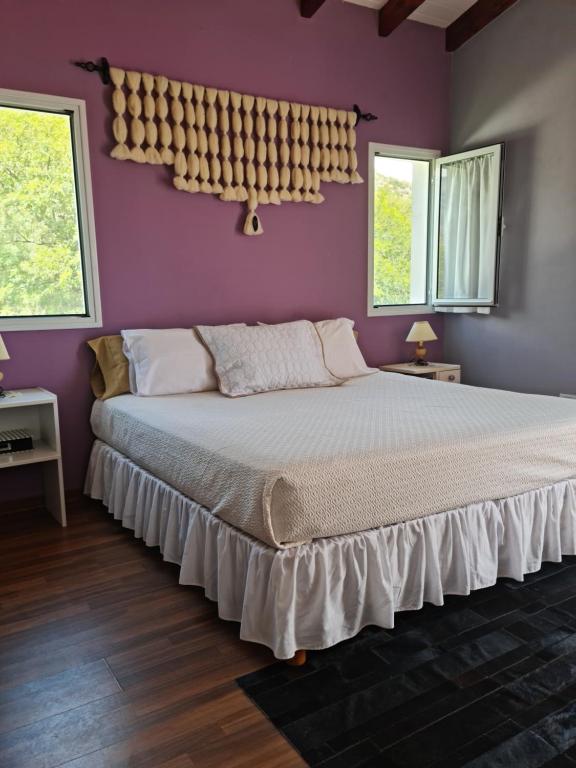 a bedroom with a large bed with purple walls at Santa Teresita in Cafayate