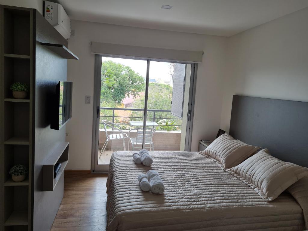 a bedroom with a bed with two slippers on it at Aires de Capital Depto in Salta