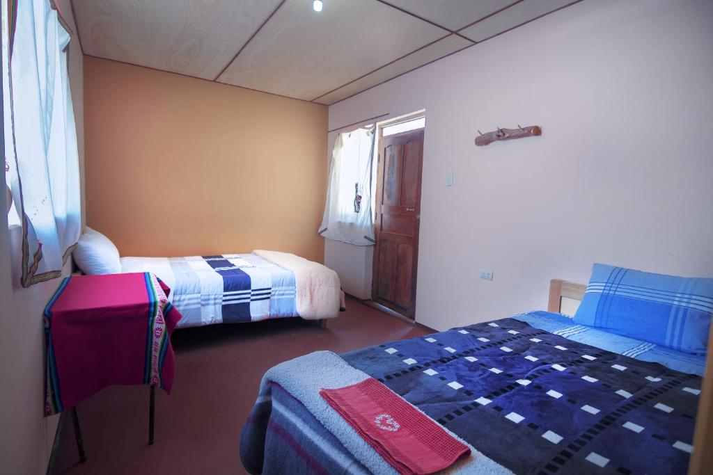 una piccola stanza con due letti e una finestra di Posada de Oliver a Llachon