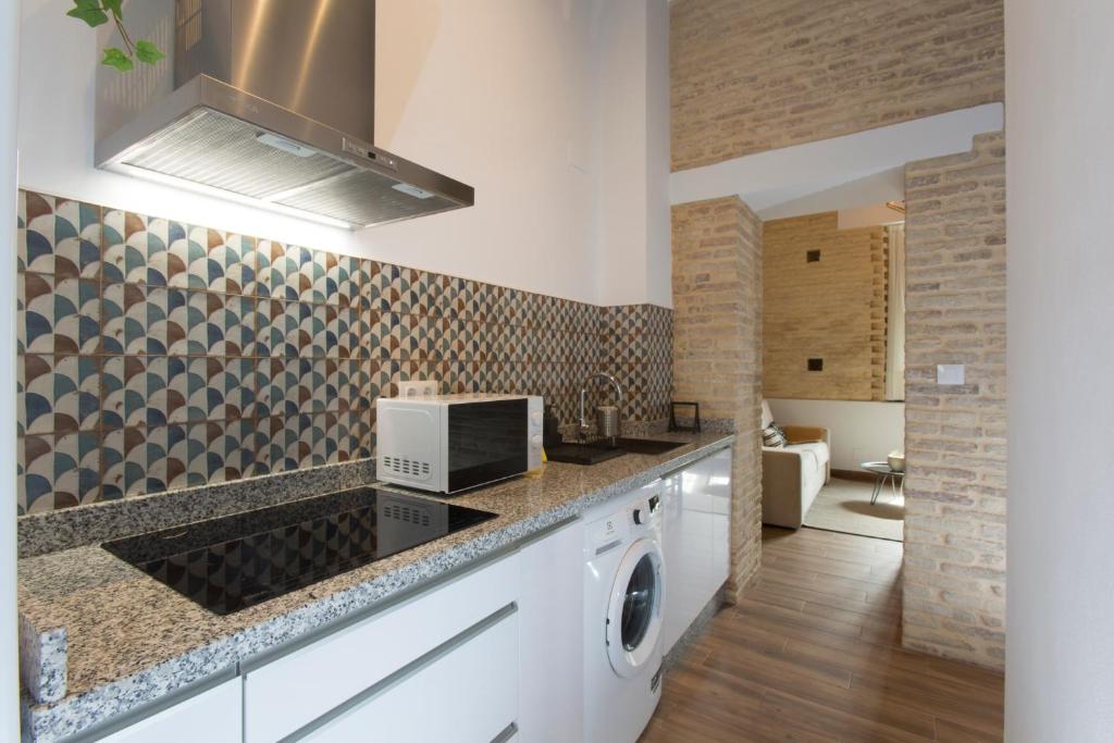 a kitchen with a washer and dryer on a counter at Alijar Casa Boutique in Castilleja de la Cuesta