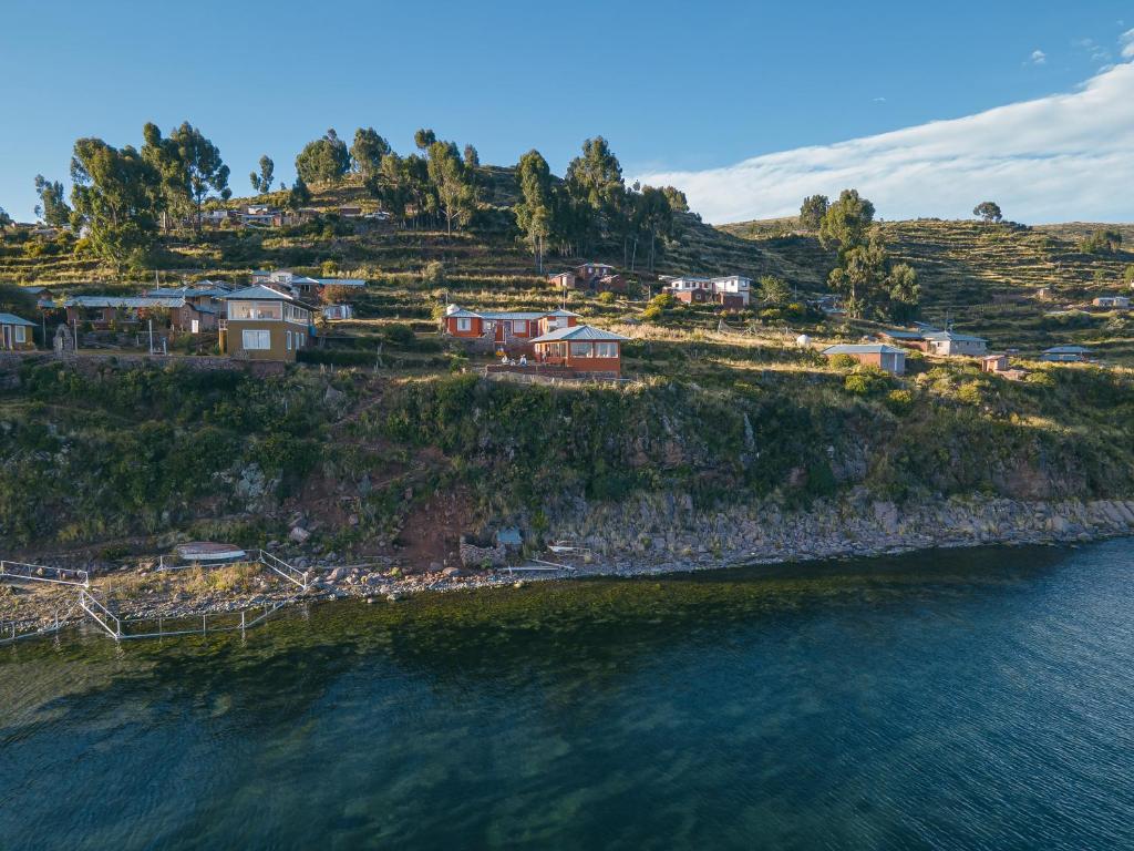 un gruppo di case su una collina vicino all'acqua di Posada de Oliver a Llachon