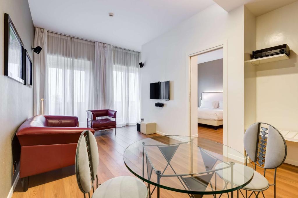 a living room with a glass table and a couch at Villa Maria Hotel & SPA in Francavilla al Mare