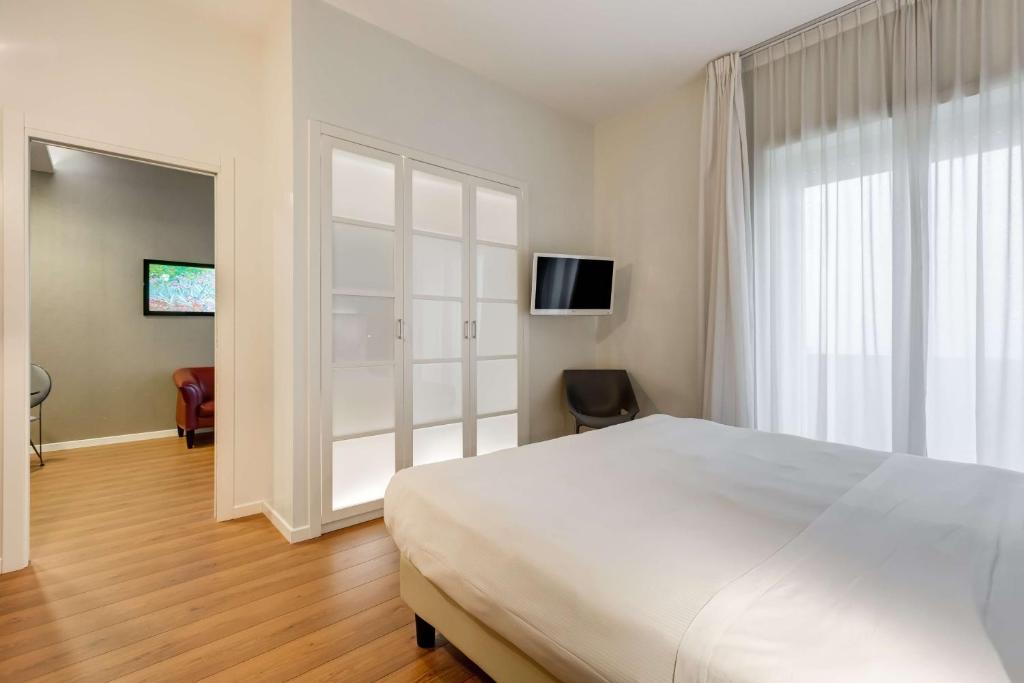 a bedroom with a white bed and a large window at Villa Maria Hotel & SPA in Francavilla al Mare