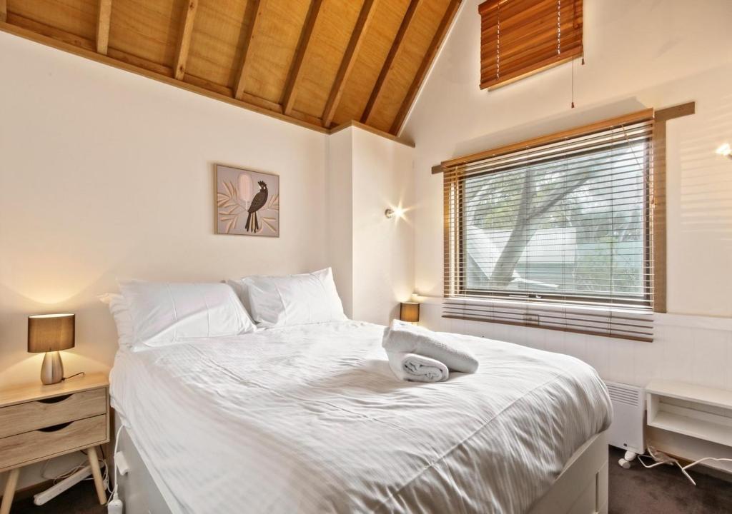 a bedroom with a bed and a desk and a window at Bogong Jacks in Dinner Plain