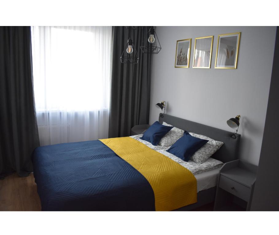 1 dormitorio con 1 cama de color azul y amarillo en Apartament w centrum przy parku na Wyspie, en Piła