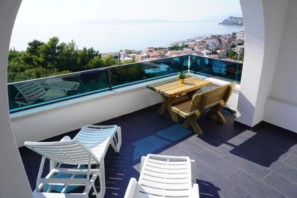 - un balcon avec une table et des chaises en bois et l'océan dans l'établissement Villa Palma, à Tučepi