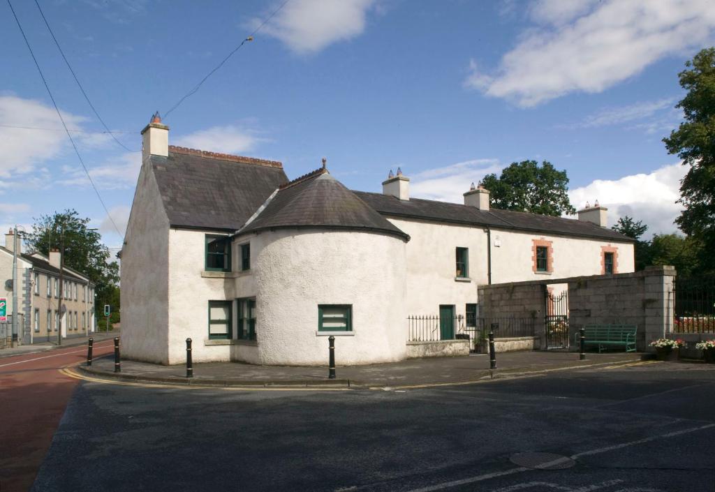 um edifício branco na esquina de uma rua em Castletown Round House em Celbridge