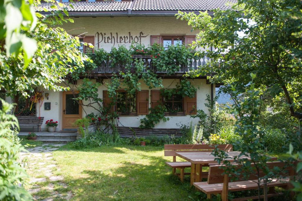 un edificio con una mesa de picnic delante de él en Residence Pichlerhof, en Rasun di Sopra