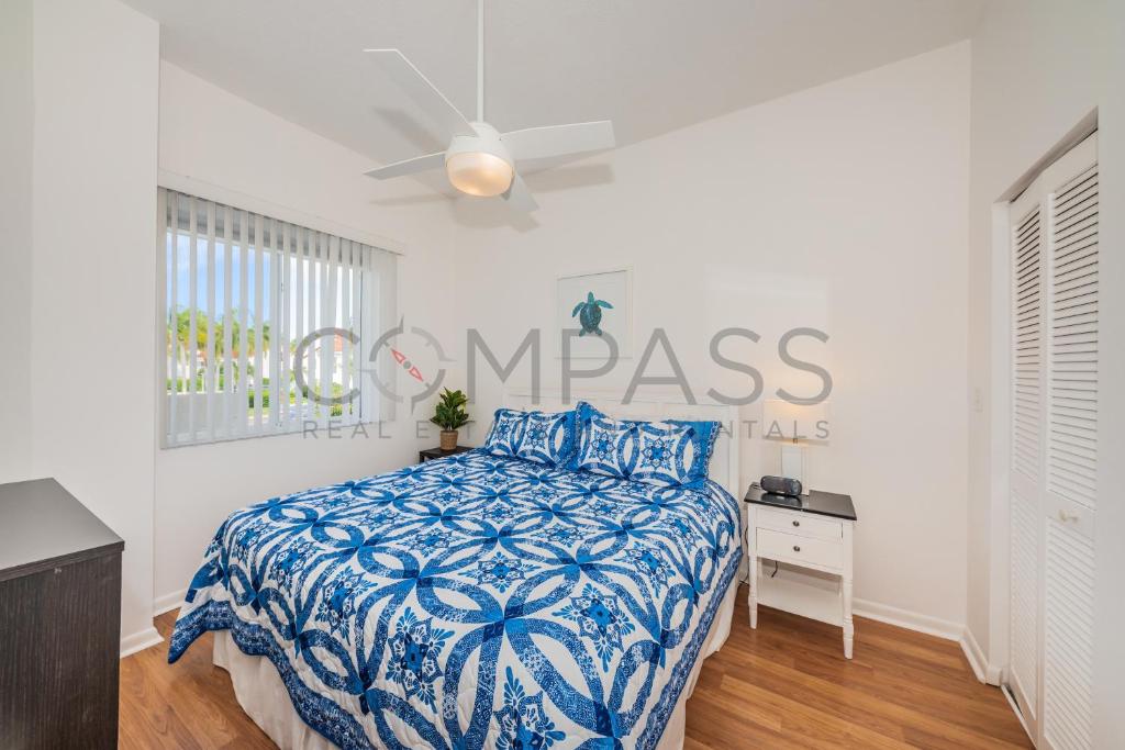 a bedroom with a bed with a blue and white comforter at Vista Verde E Beautifully Updated, Contemporary Condo in St Petersburg