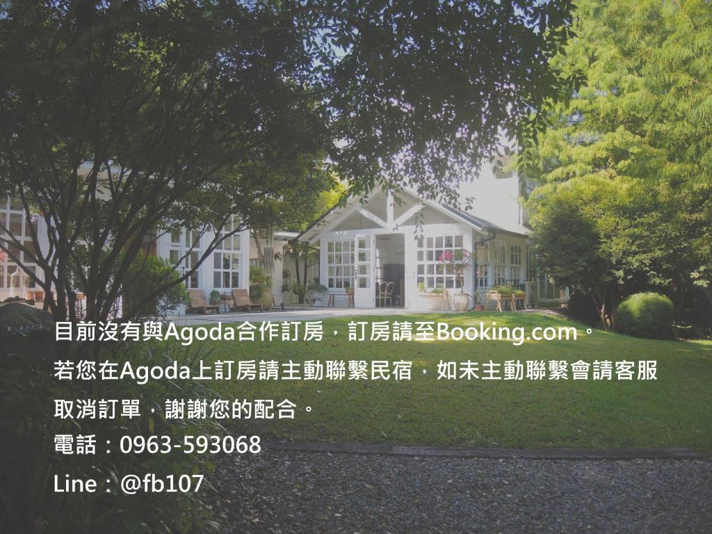 een huis met een afschrijvingsbord ervoor bij 慎重開華莊園民宿 in Puli