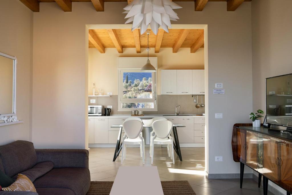 a kitchen and dining room with a table and chairs at Casa con ampio terrazzo, vista lago e giardino in Toscolano Maderno