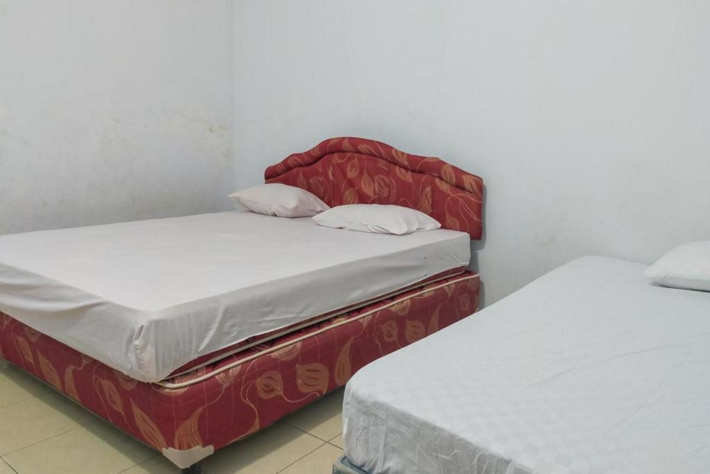 dos camas sentadas una al lado de la otra en una habitación en Fauziah Hotel Syariah Kendari en Pipulu
