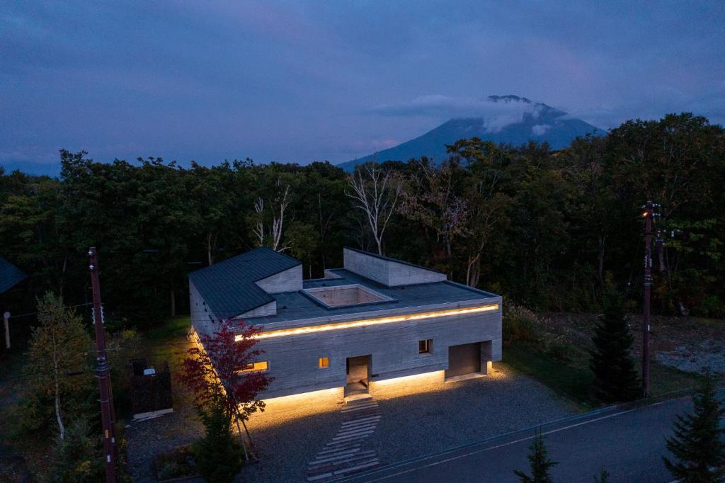 a house with lights on the side of it at night at Setsuin Niseko Hanazono in Niseko