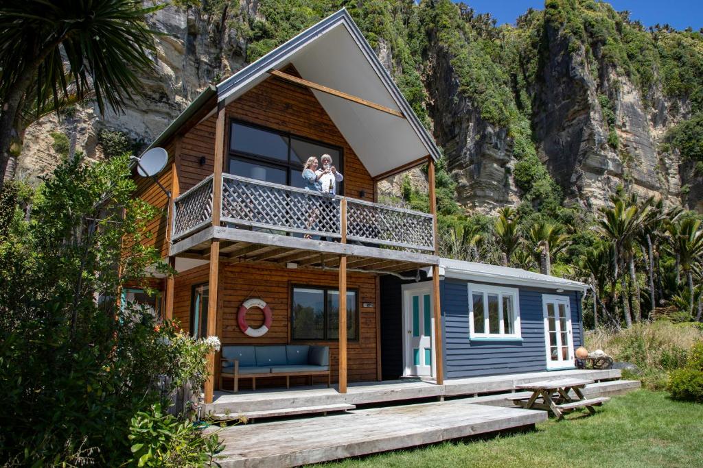 two people standing on the balcony of a tiny house at Seascapes in Punakaiki
