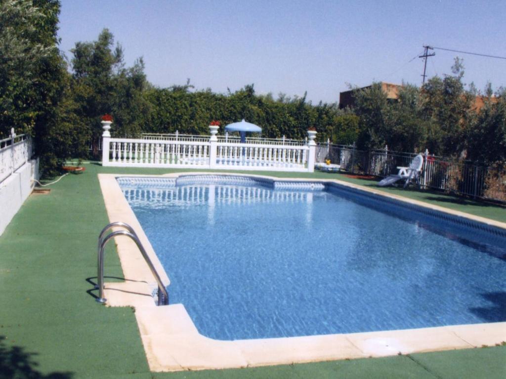 a swimming pool with a white fence around it at Private villa en baza in Baza
