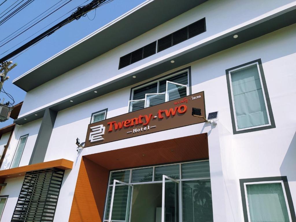a white building with a sign on it at 22 Twenty-Two Hotel ทะเวนตี้-ทู โฮเทล in Ban Pa Muat