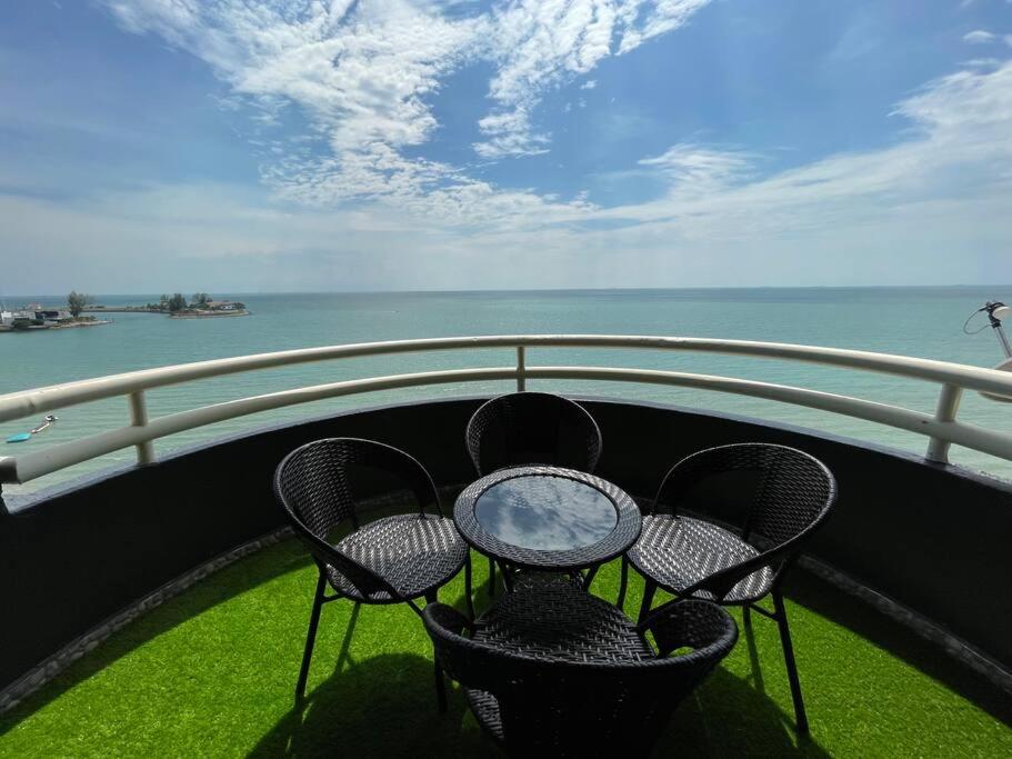 d'une table et de chaises sur un balcon donnant sur l'eau. dans l'établissement The Arena Tanjung Tuan Port Dickson, à Port Dickson