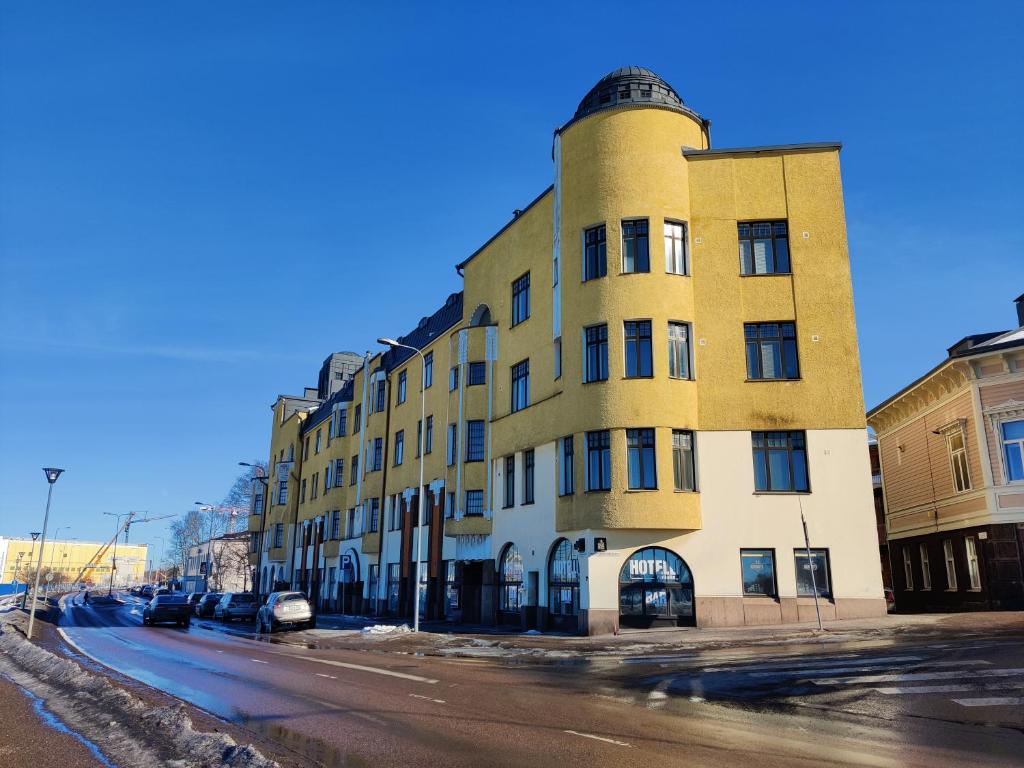 a tall yellow building on the side of a street at Hotelli Merikotka in Kotka