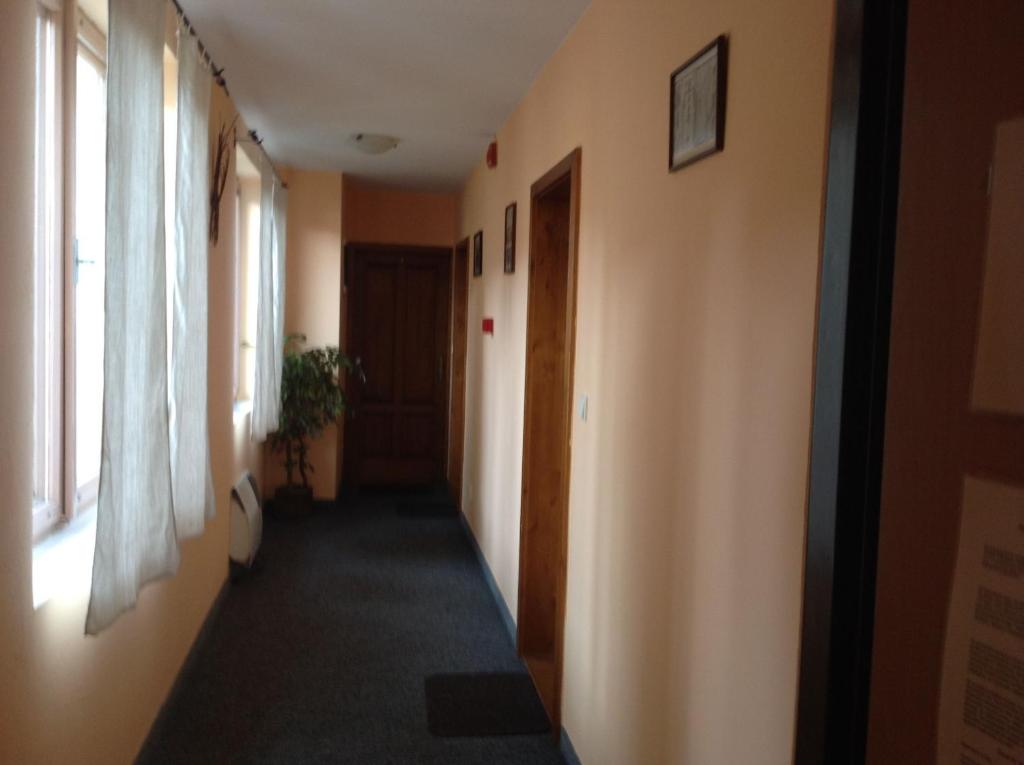 einen Flur eines Zimmers mit zwei Fenstern und einer Tür in der Unterkunft Penzion Duna in Komárno