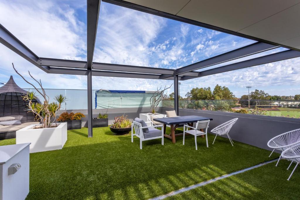 a patio with a table and chairs on the grass at Skypark on Vincent - EXECUTIVE ESCAPES in Perth