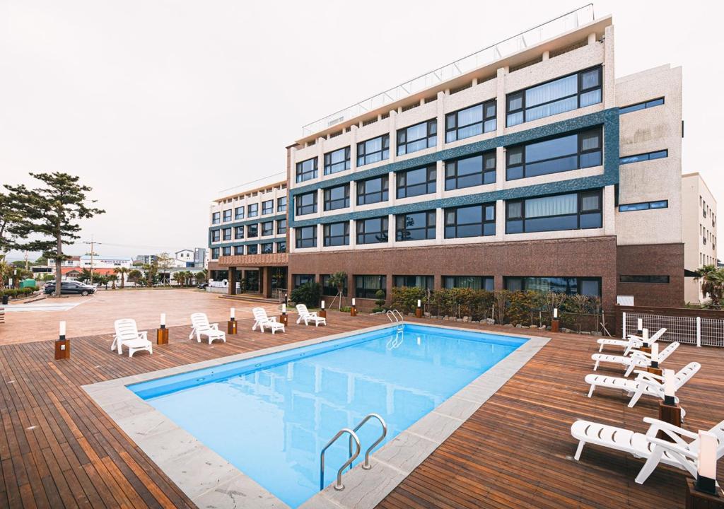 a swimming pool in front of a building at Hotel Sweet Castle Jeju Hamdeok in Jeju