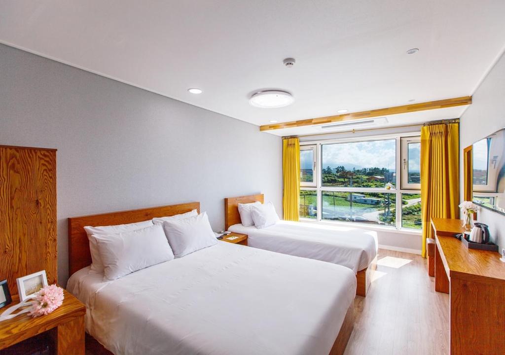 Postel nebo postele na pokoji v ubytování Hotel Sweet Castle Jeju Hamdeok