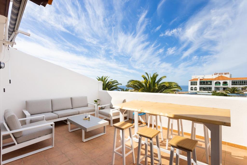 a balcony with a table and chairs and a view of the ocean at 138 ALCALA Perfect Stay by Sunkeyrents in Alcalá