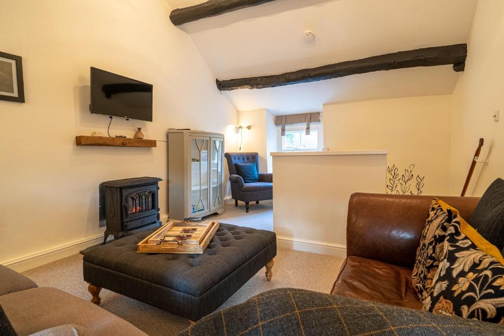 a living room with a couch and a fire place at Low Nook Cottage - Gorgeous decor in Broughton in Furness