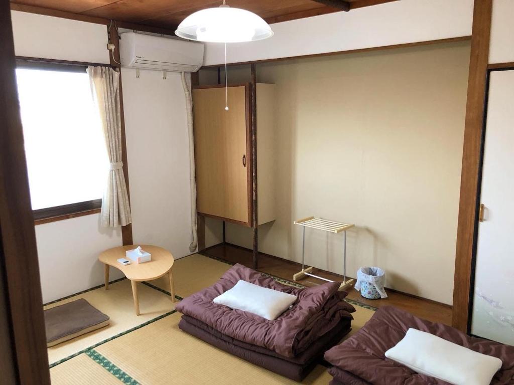 Postel nebo postele na pokoji v ubytování ゲストハウスまちかど Guest House MACHIKADO