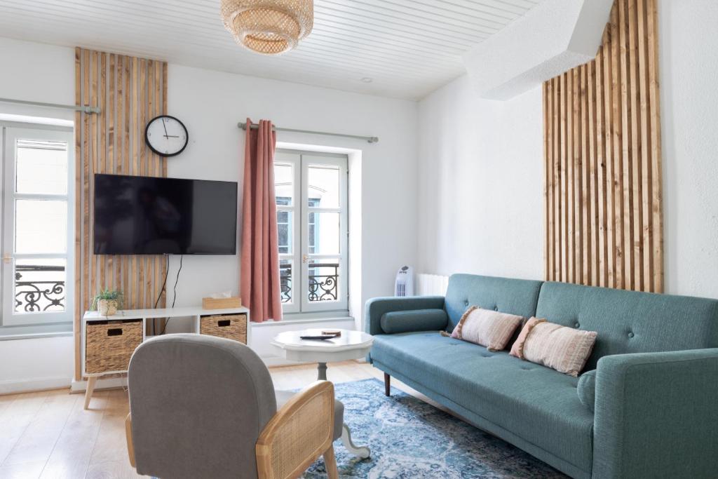 un salon avec un canapé bleu et une télévision dans l'établissement Appartement lumineux 1 chambre hypercentre Place St Jean, à Valence