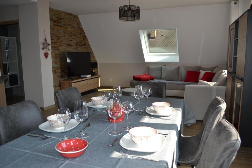 - une table à manger avec un chiffon bleu et des verres à vin dans l'établissement Gîte Les terrasses du Mambourg à Kaysersberg-Vignoble, à Kaysersberg