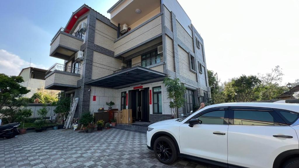 a white car parked in front of a house at Dragon Crane Resort in Puli