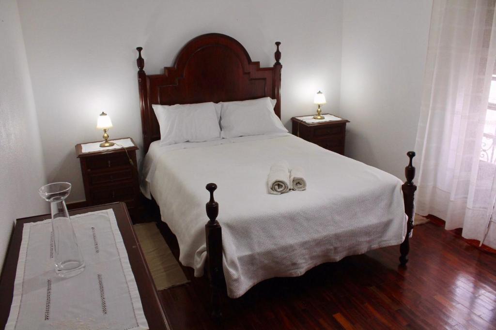 1 dormitorio con 1 cama con 2 lámparas y toallas en Casa 33, en Veiros